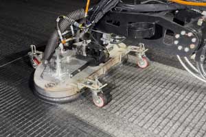 Ultra-high-pressure waterblast head removing rubber from a grooved runway